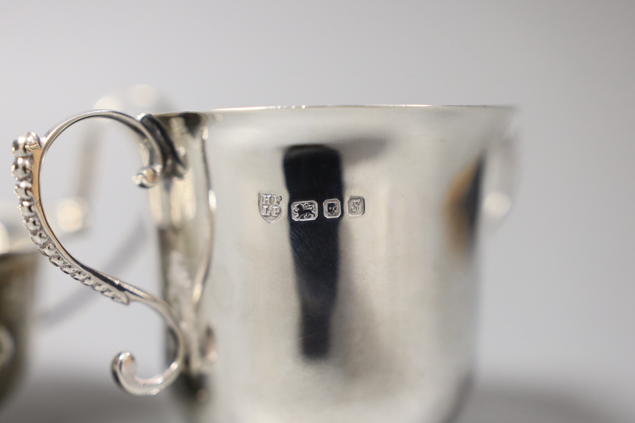 A small silver jug, Birmingham 1946 by Thomas Ducrow & Sons, together with a silver two handled cup, London 1973 by Tessiers Ltd and a silver sauceboat, 12oz.